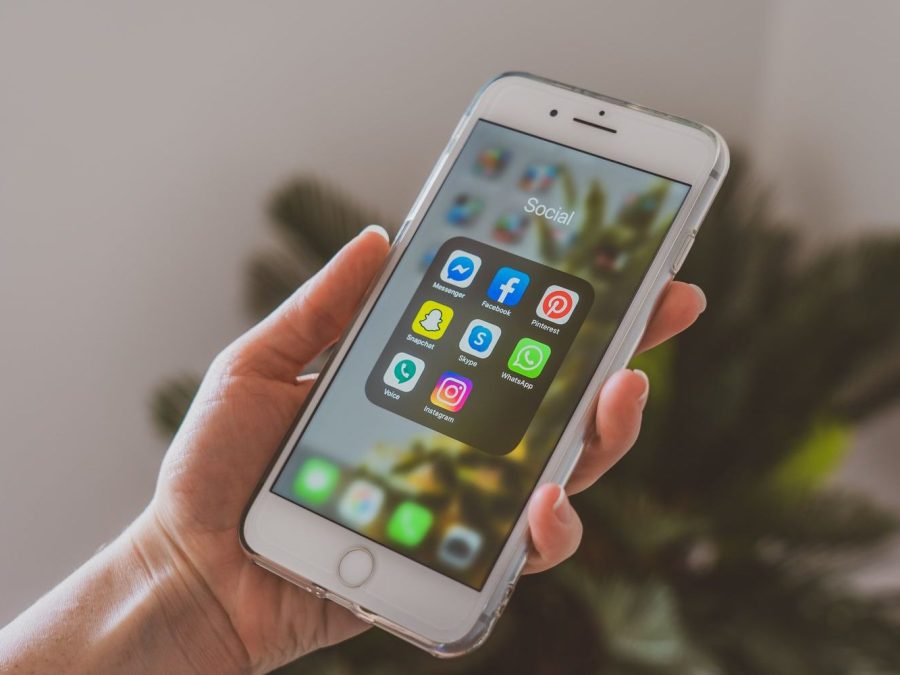 Mână care ține un smartphone cu aplicații populare de social media