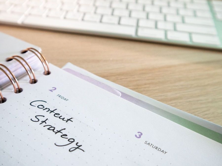 Strategie de conținut scrisă într-un planner, lângă o tastatură