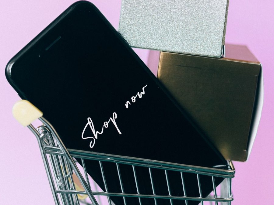 Mini coș de cumpărături, smartphone și cutii-cadou, simbol pentru cumpărăturile online