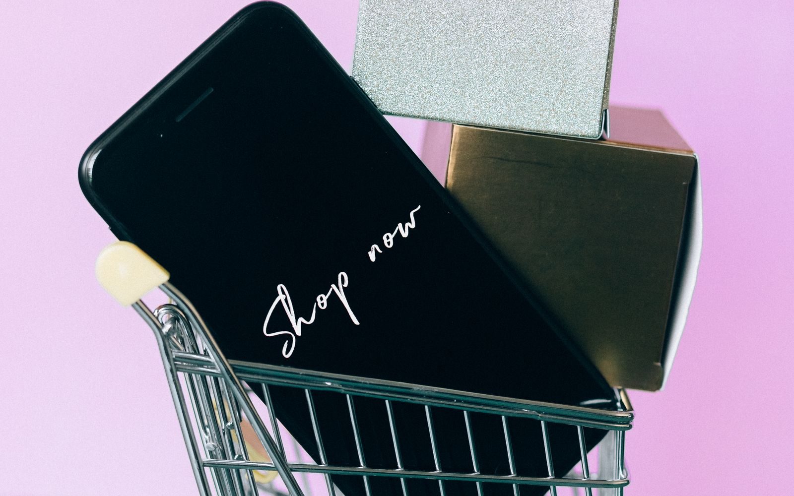 Mini coș de cumpărături, smartphone și cutii-cadou, simbol pentru cumpărăturile online