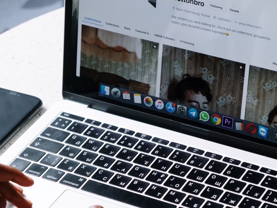 Persoană care lucrează pe laptop la o masă de cafenea