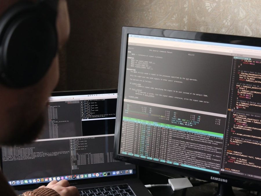 Programator concentrat, la două monitoare, cu căști