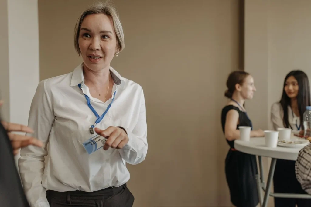 Femeie cu ecuson, care vorbește la un eveniment de networking