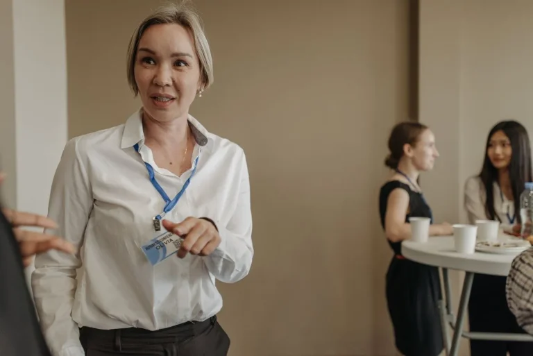 Femeie cu ecuson, care vorbește la un eveniment de networking