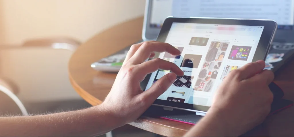 Mâini pe o tabletă, răsfoind un magazin online